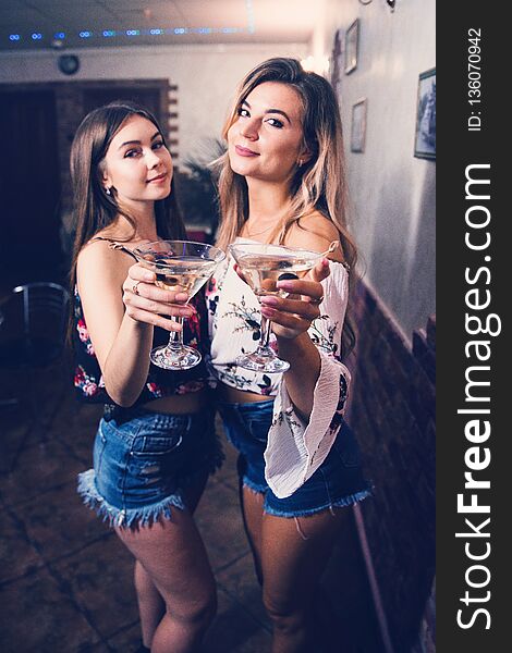 Girls At The Bar With Cocktails With A Blurred Background.