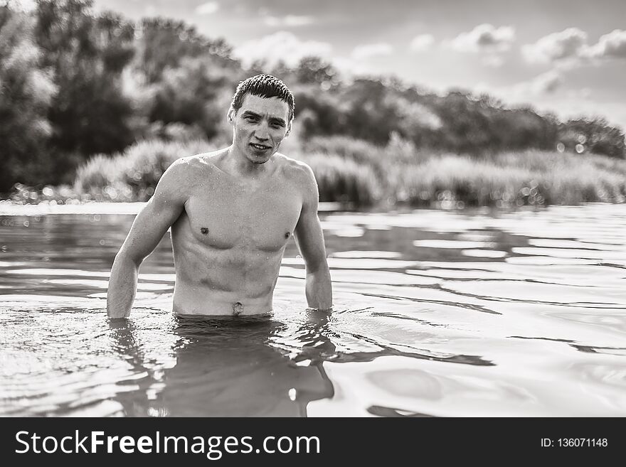 Portrait of a handsome young man in the water. Monochrome old style photo.
