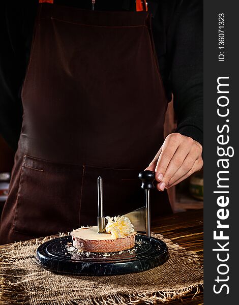 Man shave of Tete de moine cheese on a girolle. Close up view. Copy space for text, logo or brand.