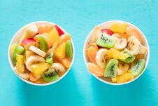 Two White Bowls Of Healthy Fresh Fruit Salad On Turquoise Background. Royalty Free Stock Image