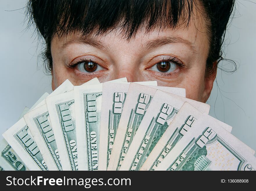 Female holding a fan of money over face. Female holding a fan of money over face