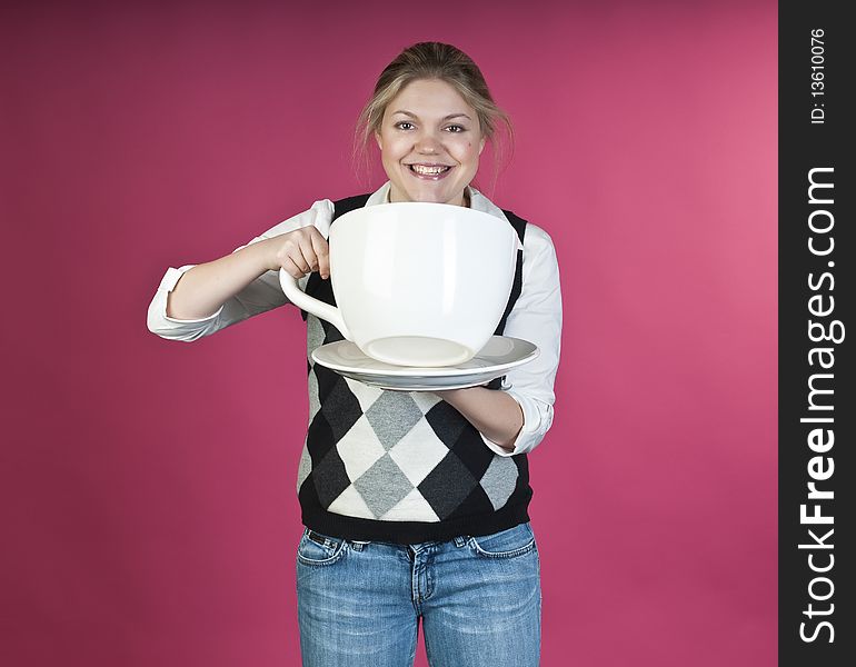 Young girl about to drink from extra large cup, studio