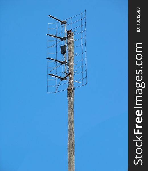 Old TV antenna over blue sky