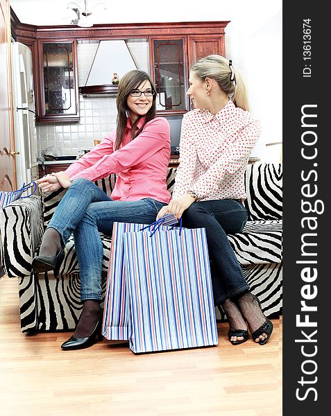Portrait of young women sitting at home with bags after shopping. Portrait of young women sitting at home with bags after shopping.
