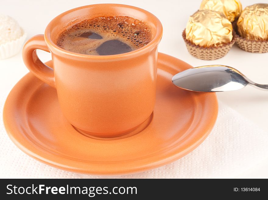 Close up of a brown ceramic cup of coffee with foam