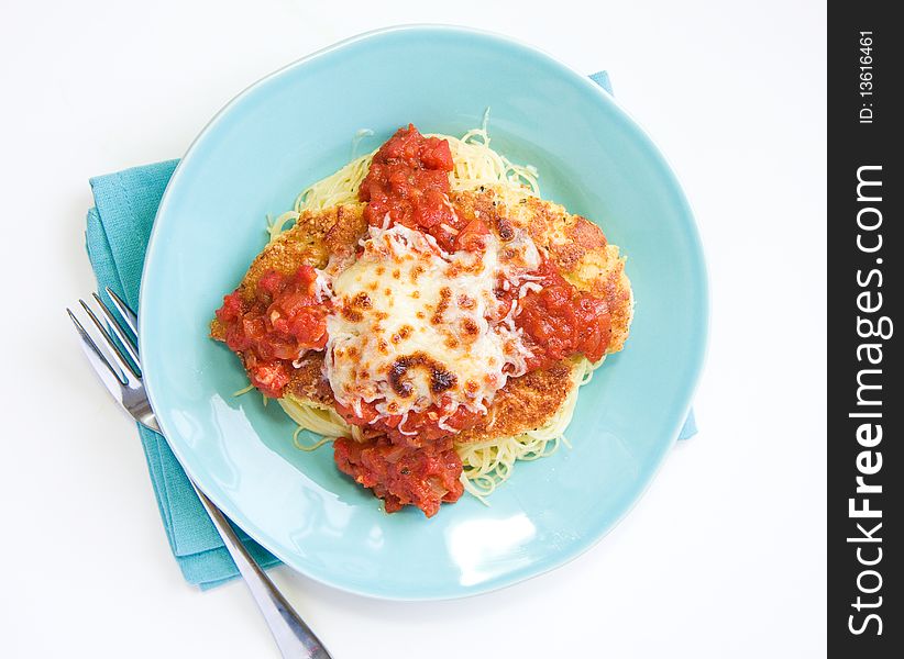 Chicken parmesan with a thick sauce served over pasta