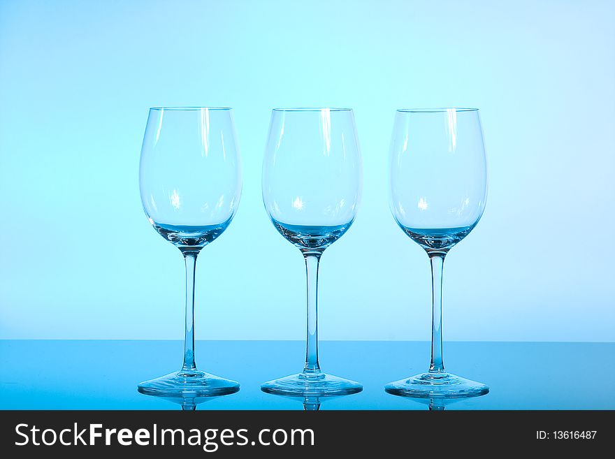 Empty wineglasses used blue light for lightning before background.