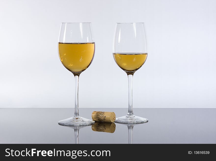 Wineglasses before a white background with wine and cork. Wineglasses before a white background with wine and cork