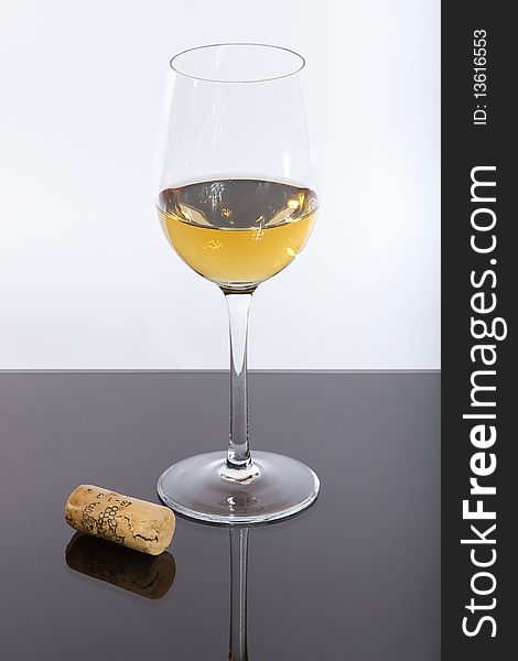 Wineglass before a white background with wine and cork. Wineglass before a white background with wine and cork.