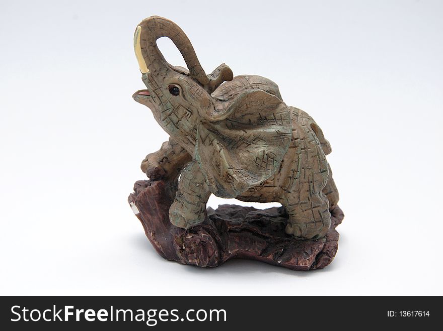 A tiny elephant figurine on a white background.