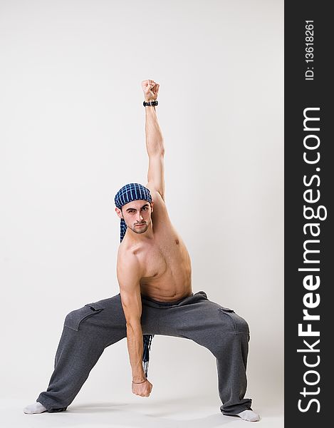 Young athletic dancer exercising, studio shot