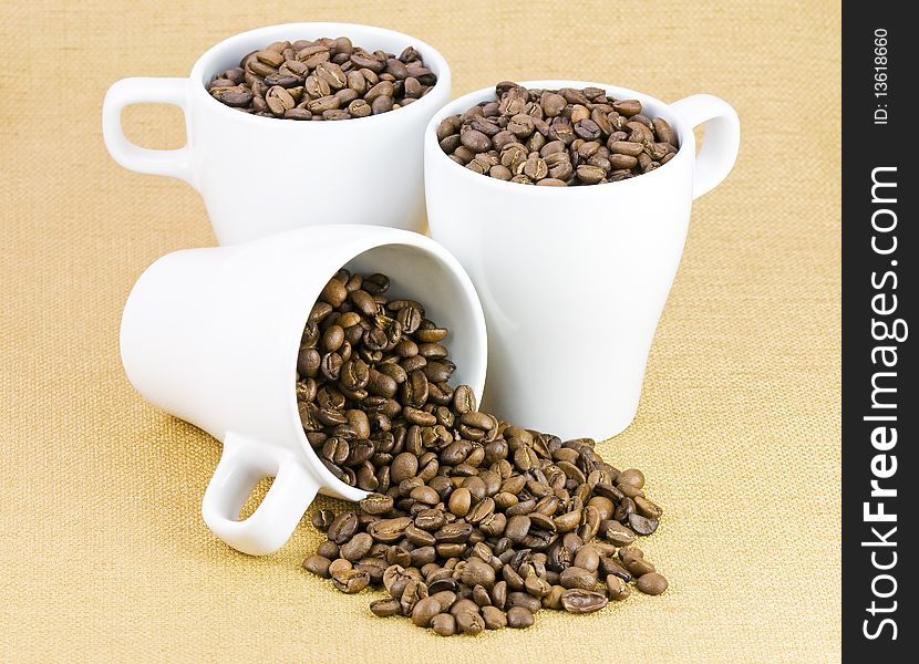 Fresh coffee beans in three white cups