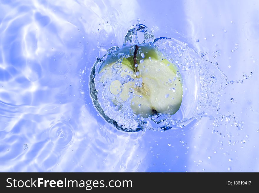 Apple with splashing  blue water. Freshness fruit