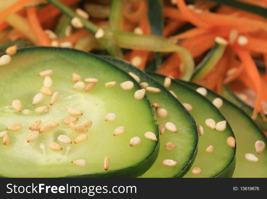 Macro photo of cucumber carrot salad presented on a white plate.