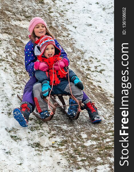 Children Enjoy Snowshoeing In The Snow Park Where The Grass Comes Out