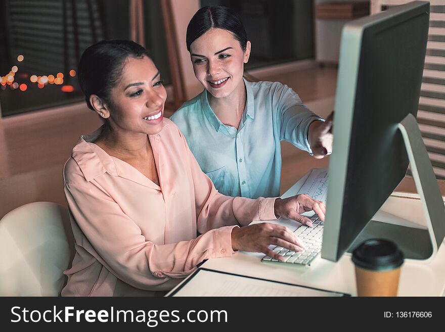 Happy Young Colleagues Working At Computer