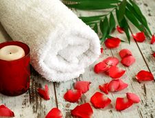 Spa Composition Of Towel, Candle And Red Petals Stock Photo