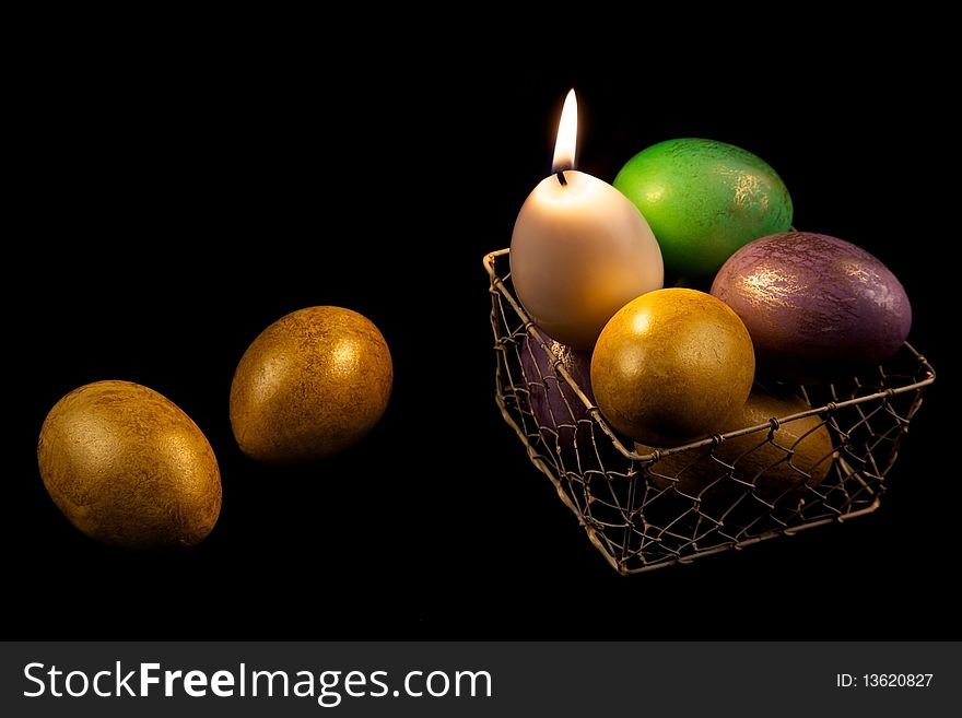 Still life with easter eggs and candle in basket