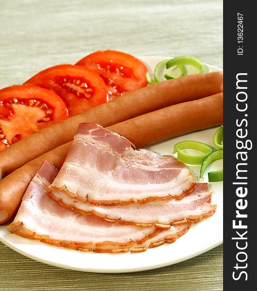 bacon, sausage and tomatoes on white plate