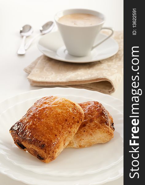 Plate of pain au chocolat and cup of cappuccino