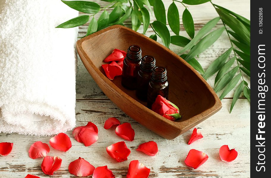 Spa composition of towel, bottles and red petals