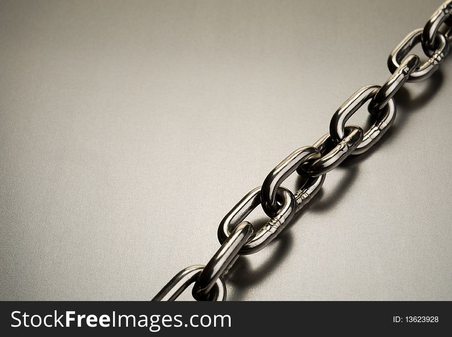 A steel chain on a metal background. A steel chain on a metal background