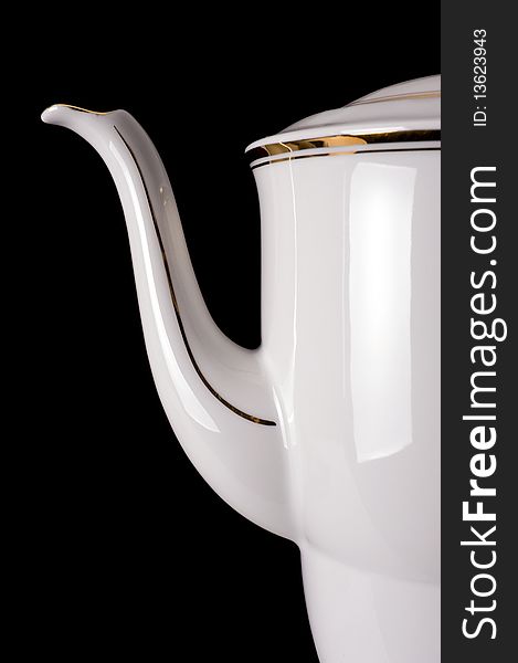 An old porcelain teapot on a black background. An old porcelain teapot on a black background