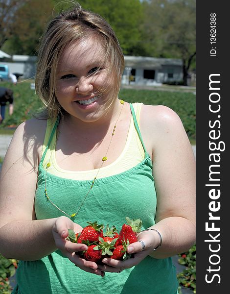 Girl holding a bunch of strawberries with her hands. Girl holding a bunch of strawberries with her hands