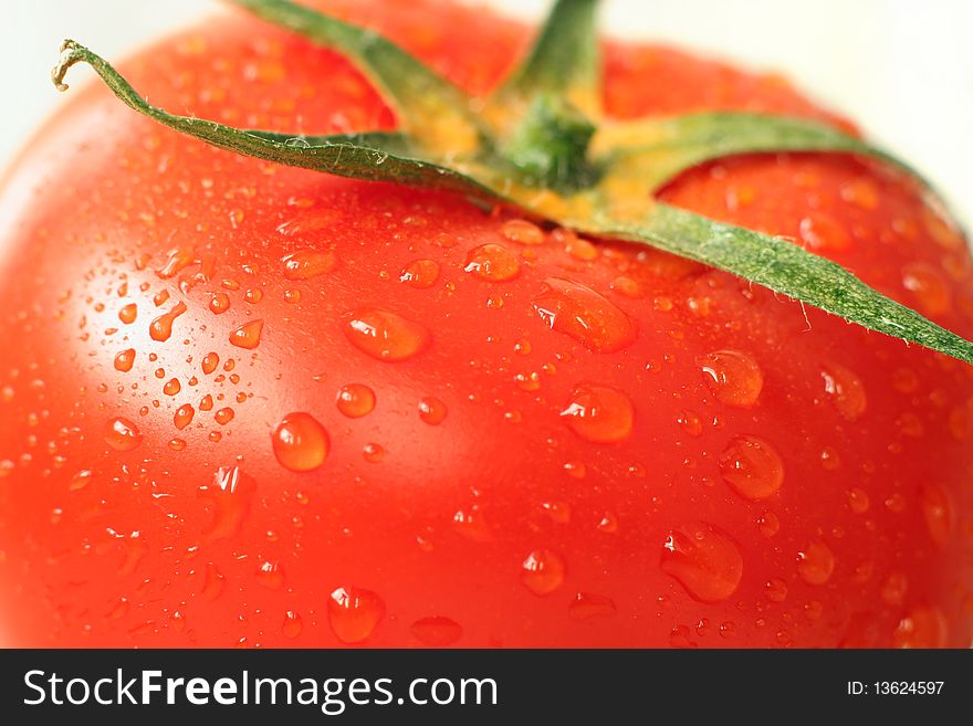 Closeup of a juicy tomato covered by water drops. Closeup of a juicy tomato covered by water drops