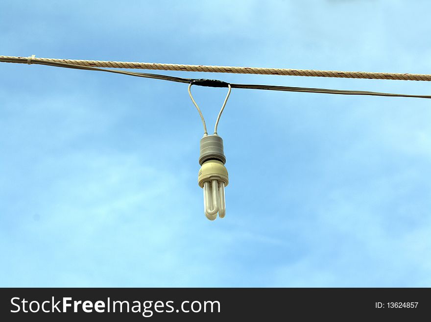 Low energy light bulb hanging in wires outside