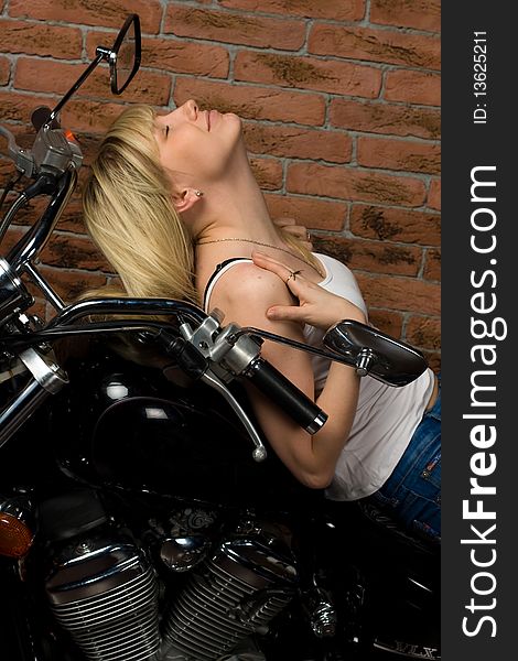 girl sitting on a motorcycle inside a studio with brick background. girl sitting on a motorcycle inside a studio with brick background