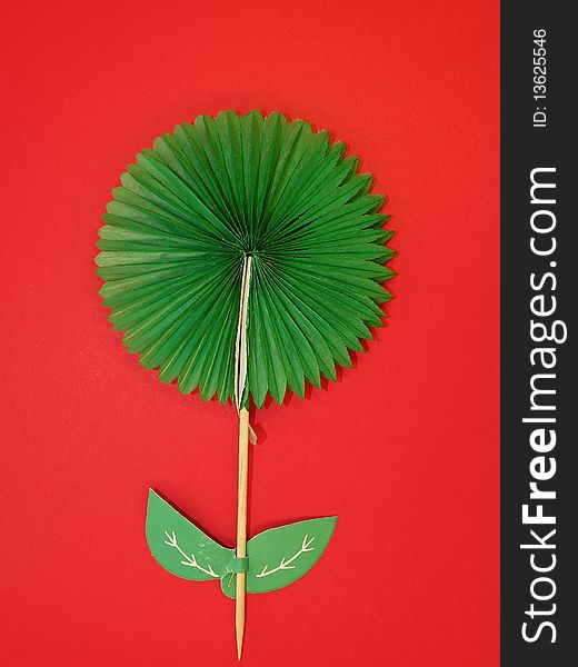 Green paper flower isolated on red