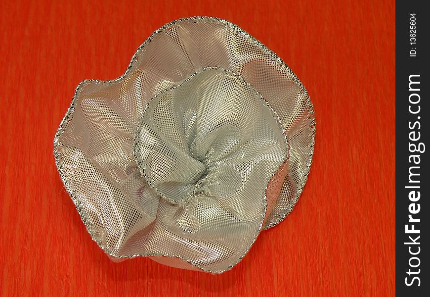 Silver ribbon flower isolated on orange