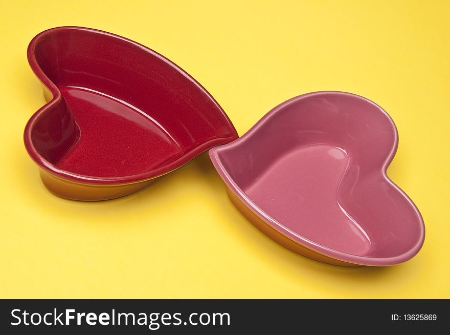 Two heart shaped bowls on a yellow background. Two heart shaped bowls on a yellow background.