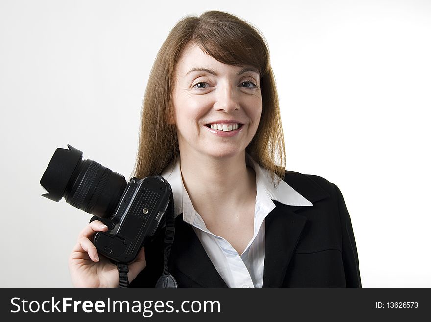 A vertical image of a pretty female photographer holding her camera and smiling. A vertical image of a pretty female photographer holding her camera and smiling