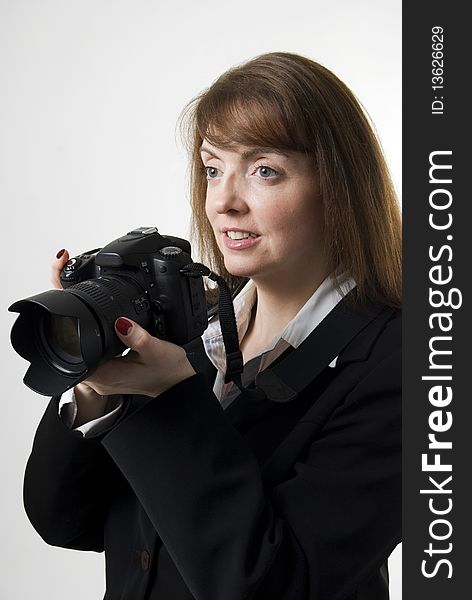 A vertical image of a pretty female photographer holding her camera and smiling. A vertical image of a pretty female photographer holding her camera and smiling