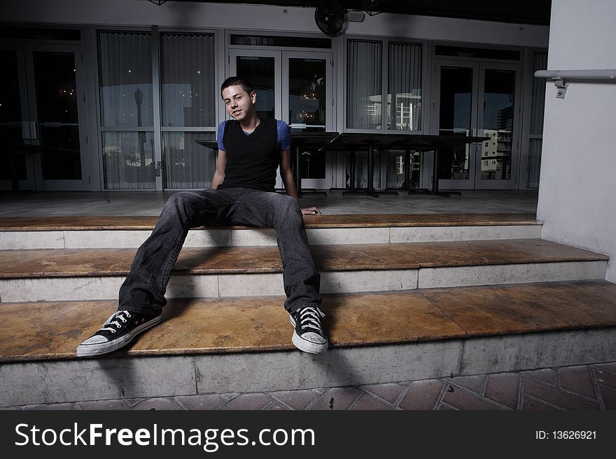 Handsome young man sitting on building steps. Handsome young man sitting on building steps