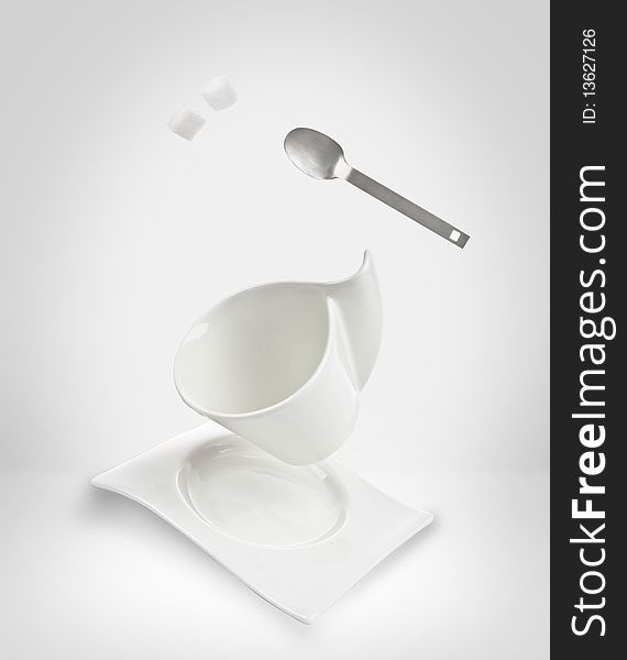 Elegant coffee cup falling with spoon and sugar