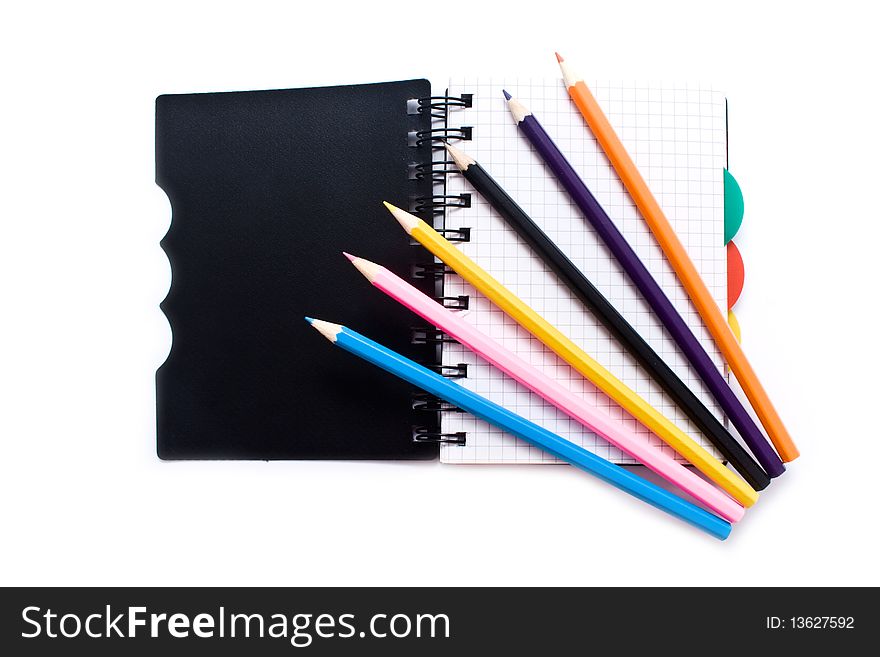 Notebook with a spring and pencils on a white background