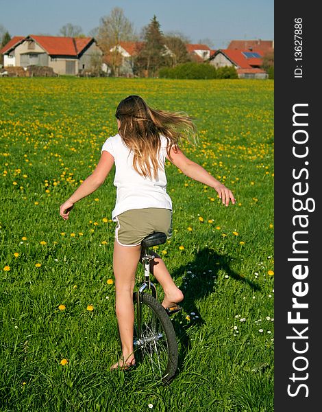 Young girl in field with her monocycle