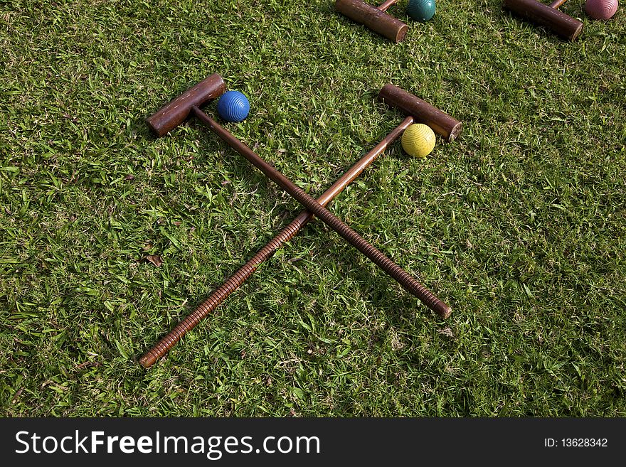 A set of croquet mallets and balls on lawn. A set of croquet mallets and balls on lawn