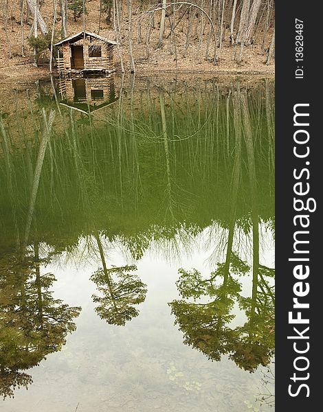 Log cabin on the shore of the lake in the forest