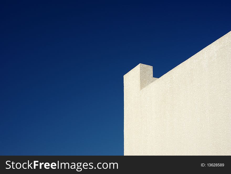 Background: yellow wall, ledge and clear blue sky. Background: yellow wall, ledge and clear blue sky