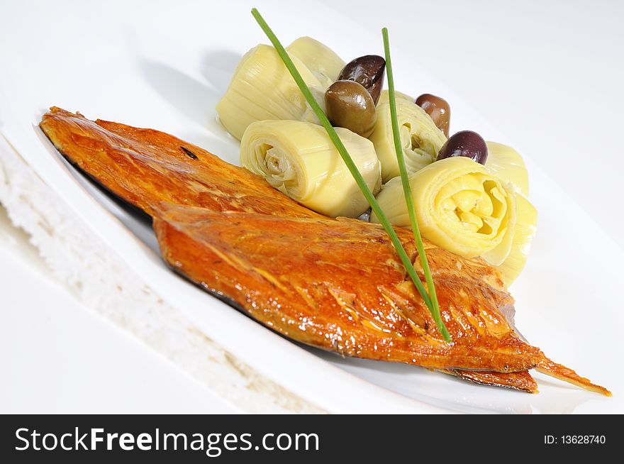 Closeup with fish, onions and olives on white plate. Closeup with fish, onions and olives on white plate