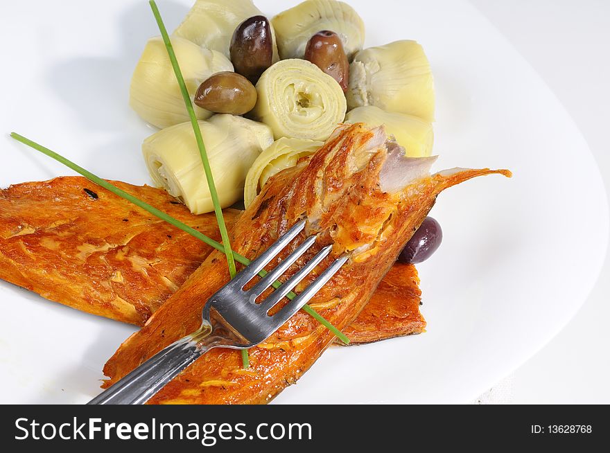 Closeup with fish, onions and olives on white plate. Closeup with fish, onions and olives on white plate