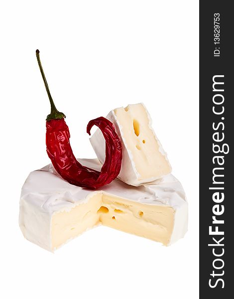 Round cheese block, cut out quarter with red chilli pepper on top over white background. Round cheese block, cut out quarter with red chilli pepper on top over white background.