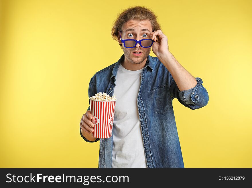 Emotional man with 3D glasses and popcorn during cinema show