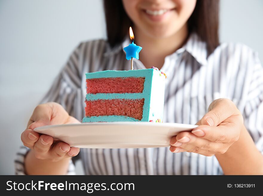 Woman holding fresh delicious birthday cake with candle