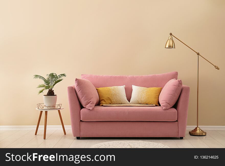 Simple living room interior with modern sofa near color wall. Space for text