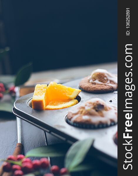 Cherry orange muffins in muffin baking pan; food background